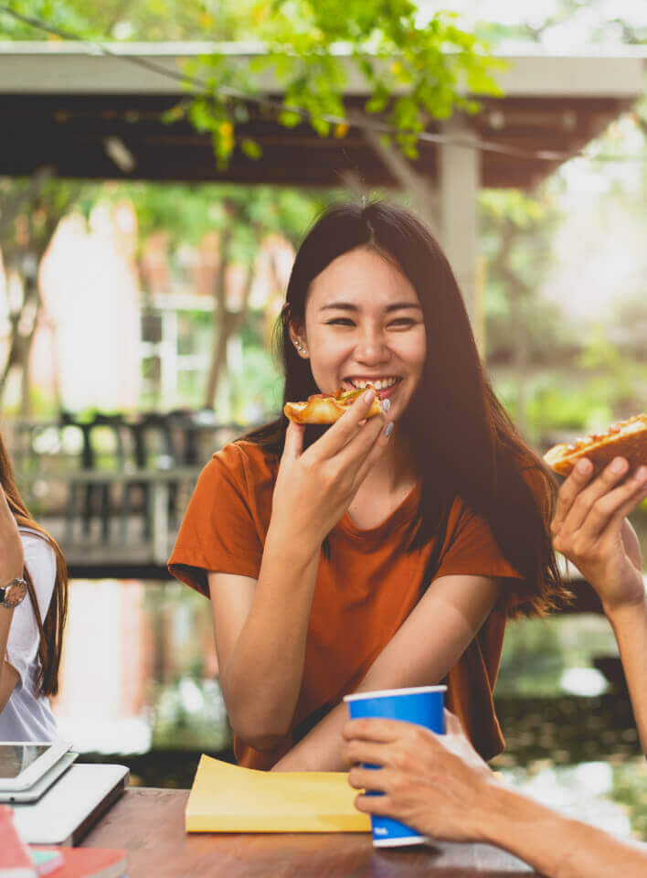Three people of different genders enjoying a meal
