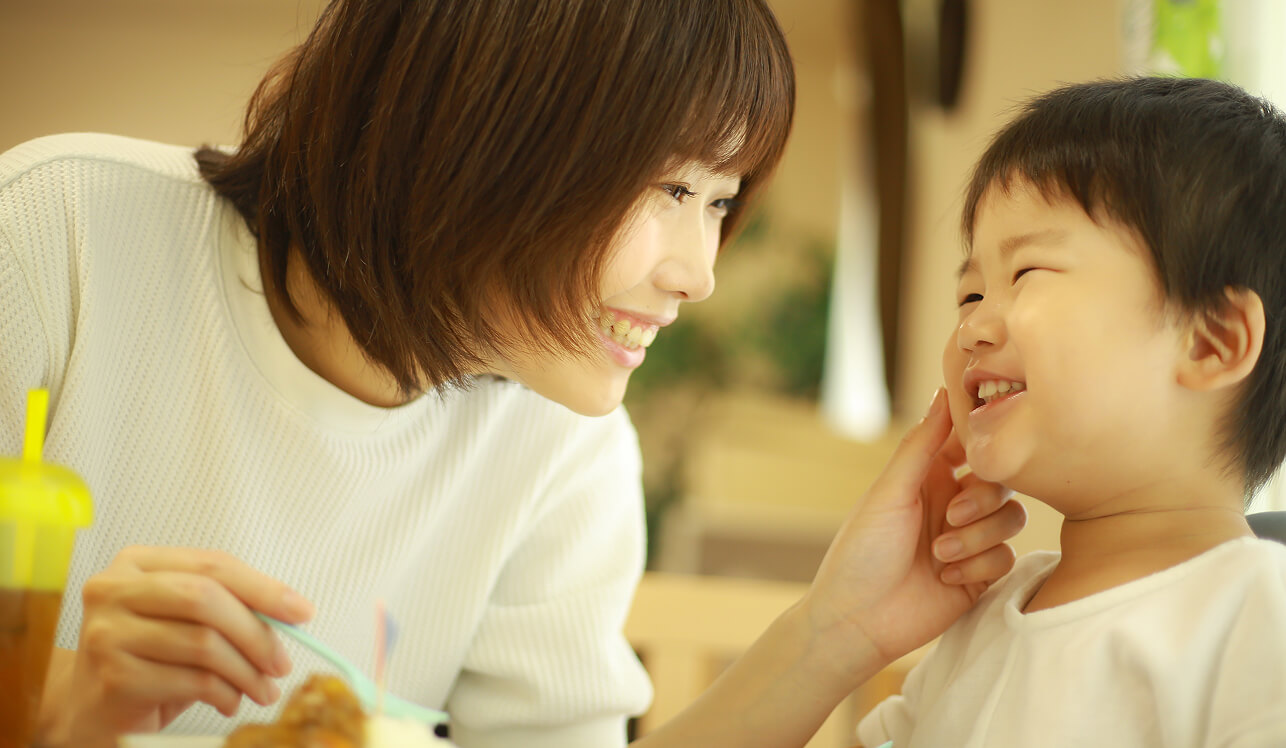 お母さんと子どもが楽しそうに食事をしている様子